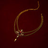 Gold necklacet with a red gemstone on a dark red background
