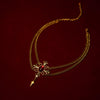 Gold necklacet with a red gemstone on a dark red background