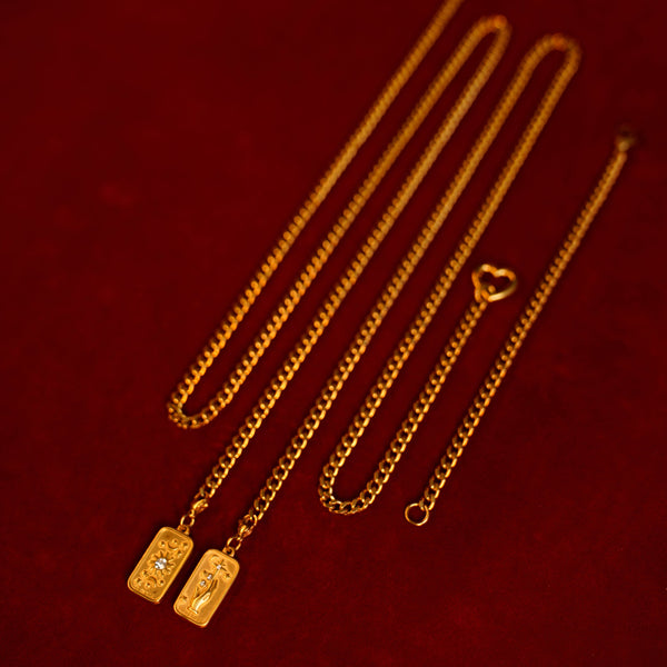 Gold couple necklaces with vintage pendants on a red background