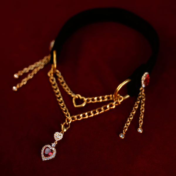 Gold chain black velvet necklace with heart-shaped pendant on a dark background