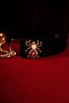 Gold-tone spider ornament with clear crystals and red teardrop stone