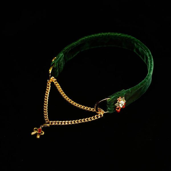 Green velvet headband with gold chain and red gemstones on a black background