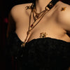 VelourBliss Halloween editorial with a black velvet choker, layered gold-tone chains and spider accents above a black lace neckline.