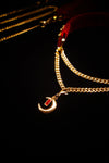 Layered gold chains with crescent moon and red crystal pendant