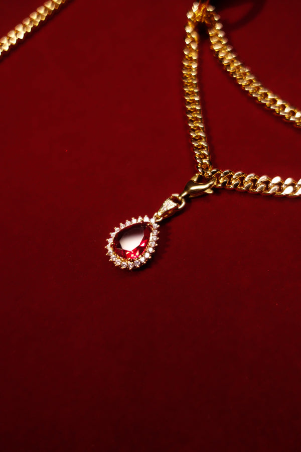 Layered gold-tone chains with red crystal pendant