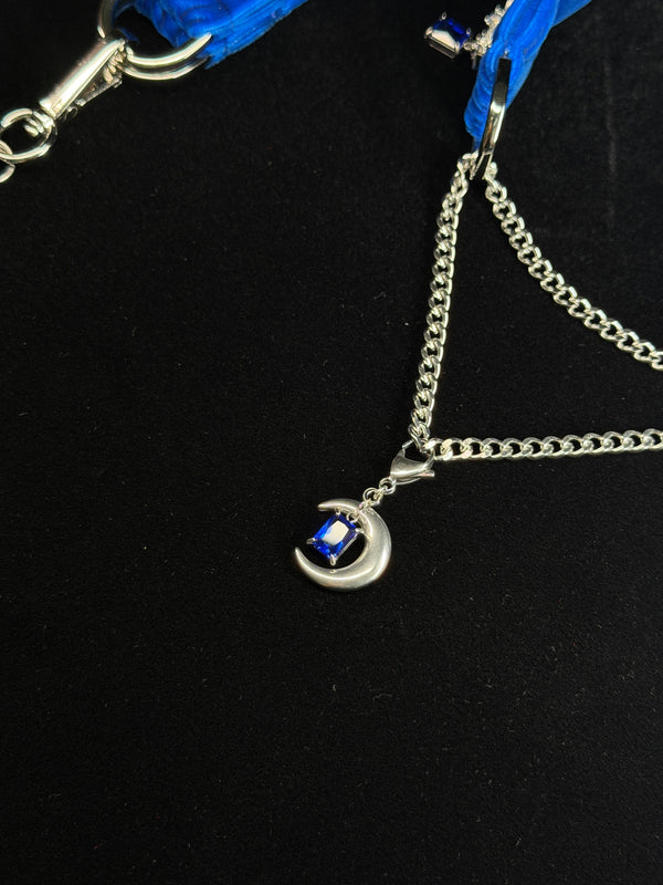 Moon-shaped blue crystal pendant and silver chain detail