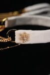 Close-up of the gold-tone snowflake ornament with clear accents on the white band