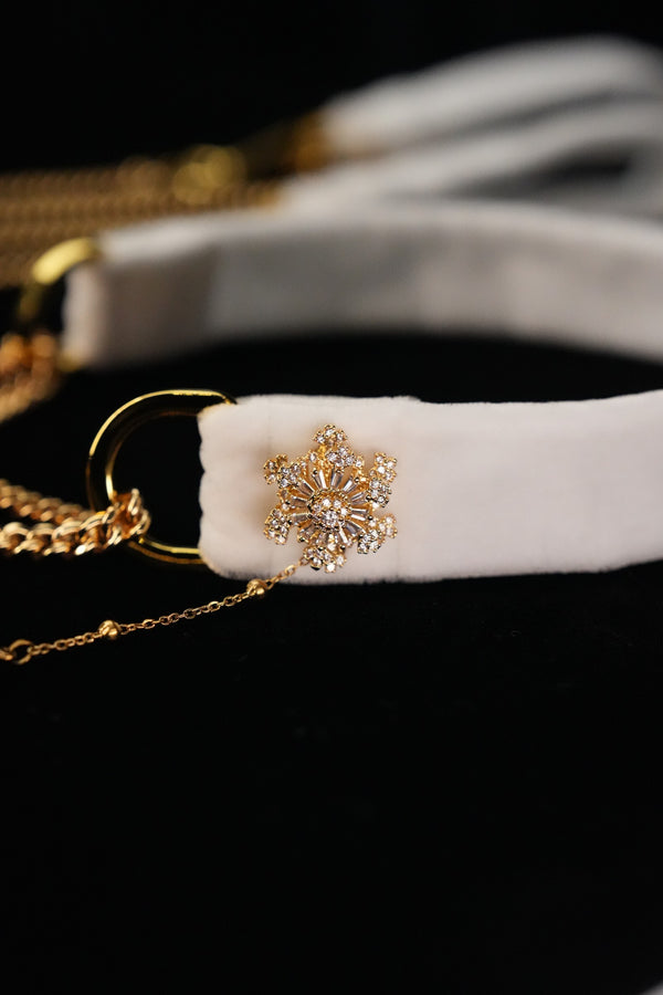 Close-up of the gold-tone snowflake ornament with clear accents on the white band