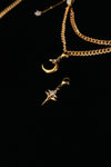 Crescent moon and cross-shaped star pendants beneath layered gold-tone chains