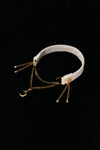 IVORY REVERIE white choker with layered gold-tone chains, a crescent moon and side tassels