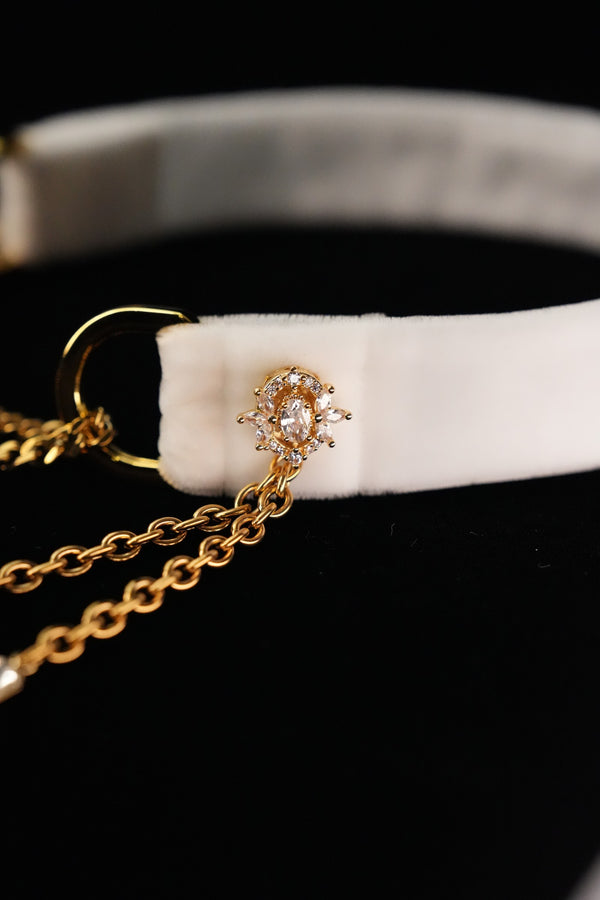 Oval floral-style ornament with clear accents on the white choker band