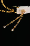 Close-up of gold-tone side tassels with clear accents at the ends