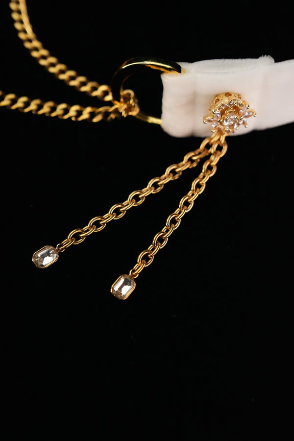 Close-up of gold-tone side tassels with clear accents at the ends
