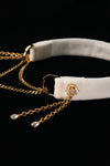 Side view of the white choker showing gold-tone rings and layered chains