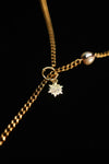 Detailed sun charm and circular clasp on the gold-tone pearl chain