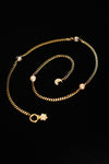 Full necklace laid in a spiral showing pearl accents and sun and moon charms