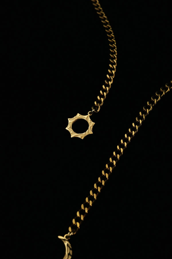 Close-up of the open sun motif on the gold-tone chain