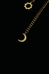 Close-up of the crescent moon charm at the end of the gold-tone necklace